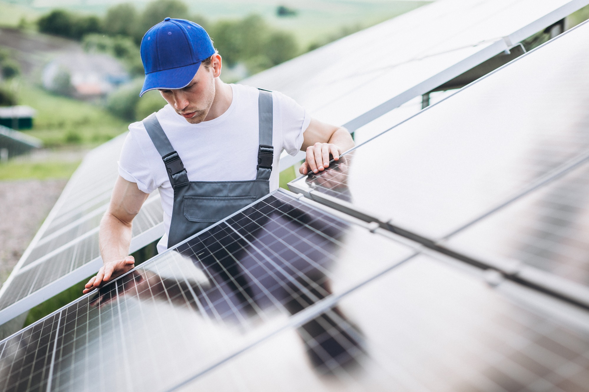 Man Worker in the Firld by the Solar Panels.