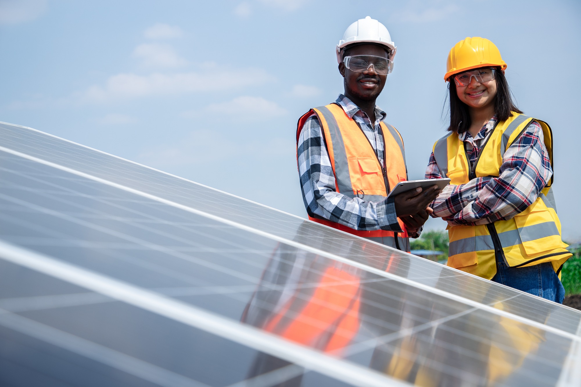Two Workers Technicians Installing Heavy Solar Photo Voltaic Panels to High Steel Platform in Corn Field.