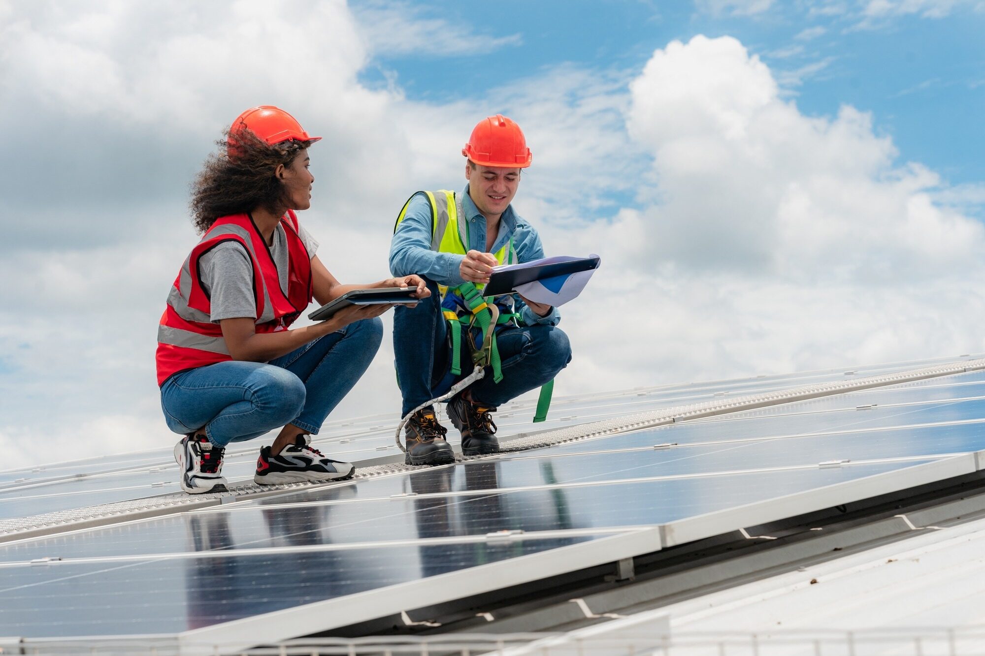 Professional Specialist Technician Engineer Working to Maintenance Checking and Installing Solar Roof Panel on the Factory Rooftop Under Sunlight.